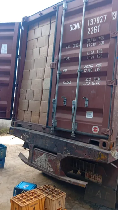 A 20ft shipping container at our yard in Lagos, doors open and stacked with cartons of food cargo for sea freight from Nigeria to the UK.